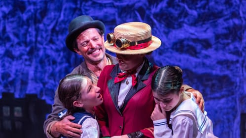 A smiling, sooty-faced Bert & two kids in sailor suits huddle affectionately around Mary, whose face is shaded by her hat.