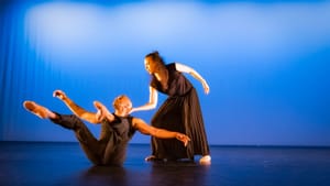 Balancing on his butt with limbs seeming to float, Rainey has his head supported by Moss-Thorne, behind him on her feet.