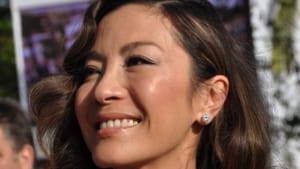 A closeup snapshot of Yeoh outdoors at a film festival, wearing a black sequin dress and necklace.