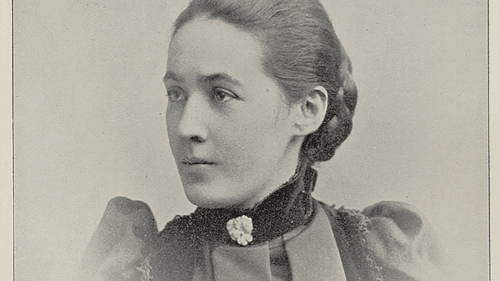 Vintage photo of Nichols from the shoulders up. Her hair is pulled back into a braided bun and she looks serenely to the side