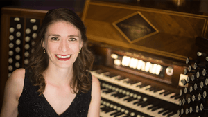 Portrait photo of Berney smiling in front of an organ piano