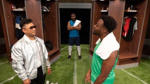 Jimenez, in a silver jacket, faces off with Sesay in a locker room with a green turf floor while Grant watches, arms folded.
