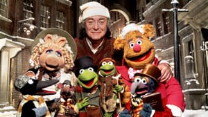 A group of Jim Henson’s Muppets in Christmas gear in a snowy backdrop, Michael Caine as Scrooge stands with them