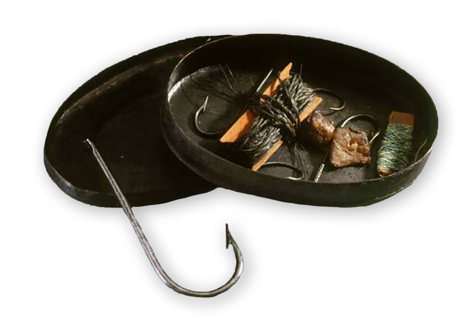 Small oval metal box with its two halves open, with fishing hooks and hanks of old string in it.