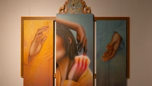 A triptych piece within a wooden frame has hands of different skin tones reaching and interacting, two in the center touching
