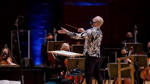 Yannick Nézet-Séguin conducts the orchestra at Verizon Hall. He wears a striking patterned black-and-white shirt.