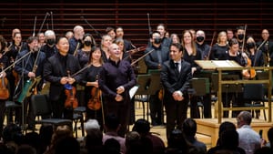 Yannick Nézet-Séguin & Iman Habibi smile on the Verizon Hall stage in front of a standing ovation, the orchestra behind them