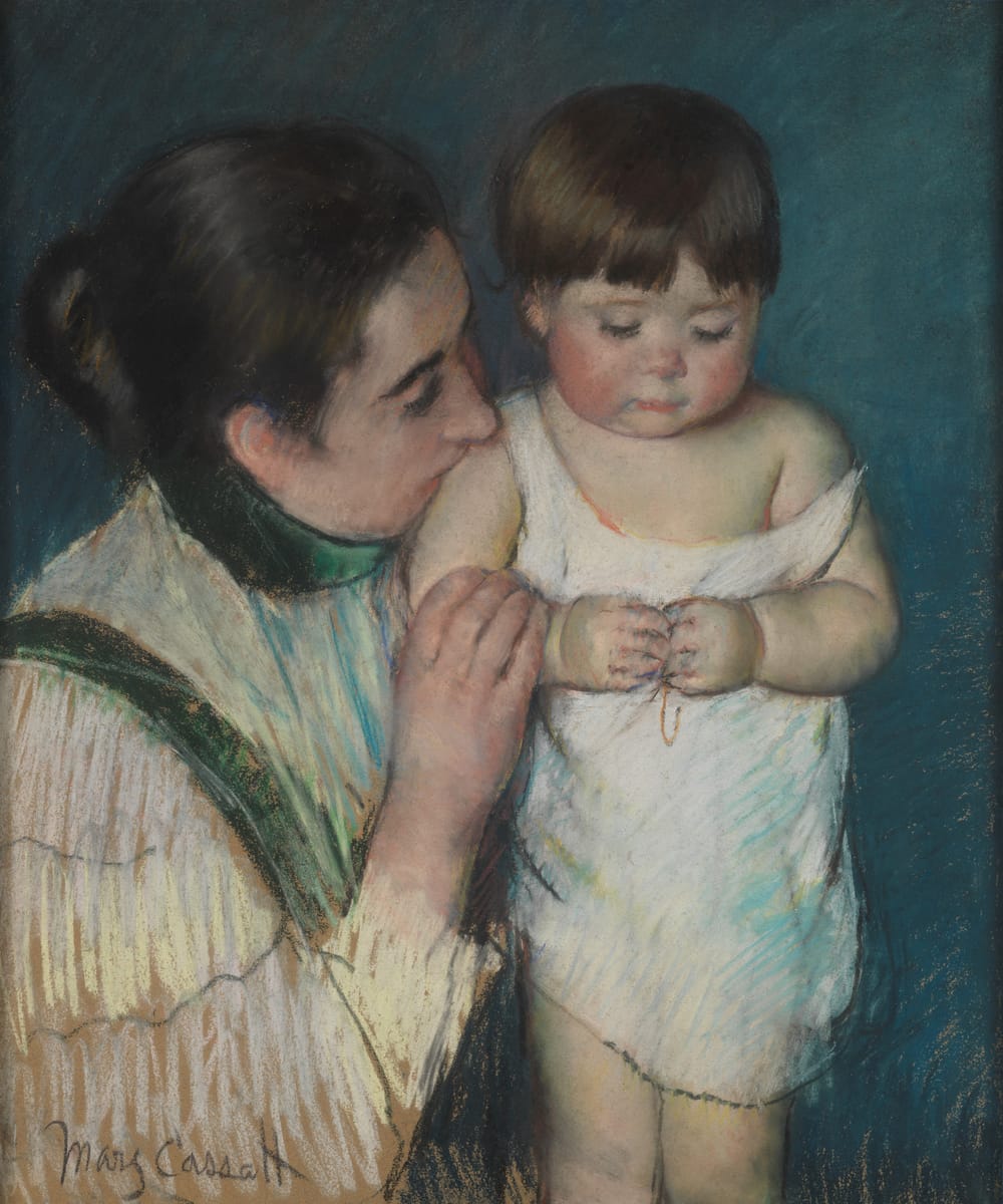 Dark-haired mother kisses the shoulder of a chubby rosy-cheeked dark-haired toddler in a white shift falling off his shoulder
