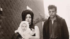 Black & white photo shows the white family described in the article. There’s a high wall behind them with bushes at its base.