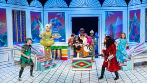 A colorful, vibrant stage with Peter Pan and Tinkerbell, and Hook at opposite sides squared off. Other performers on stage