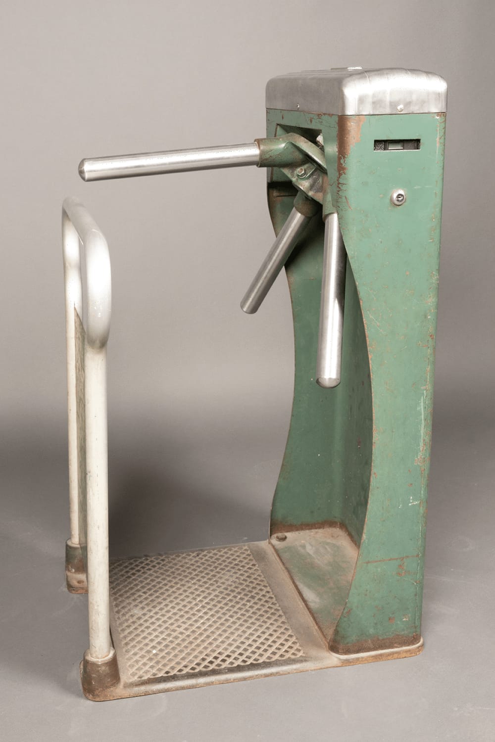 A single vintage turnstile with an olive green body and bright metal arms.