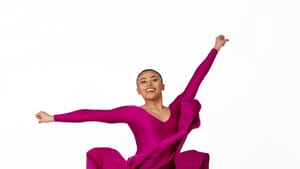 Wright, a smiling Black dancer leaps in strappy brown sandals & a magenta dress, the skirt billowing up around her hips.