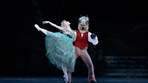 In diaphanous green tulle, Maslova throws one leg back next to Sprance, in a red vest and large plush donkey head.