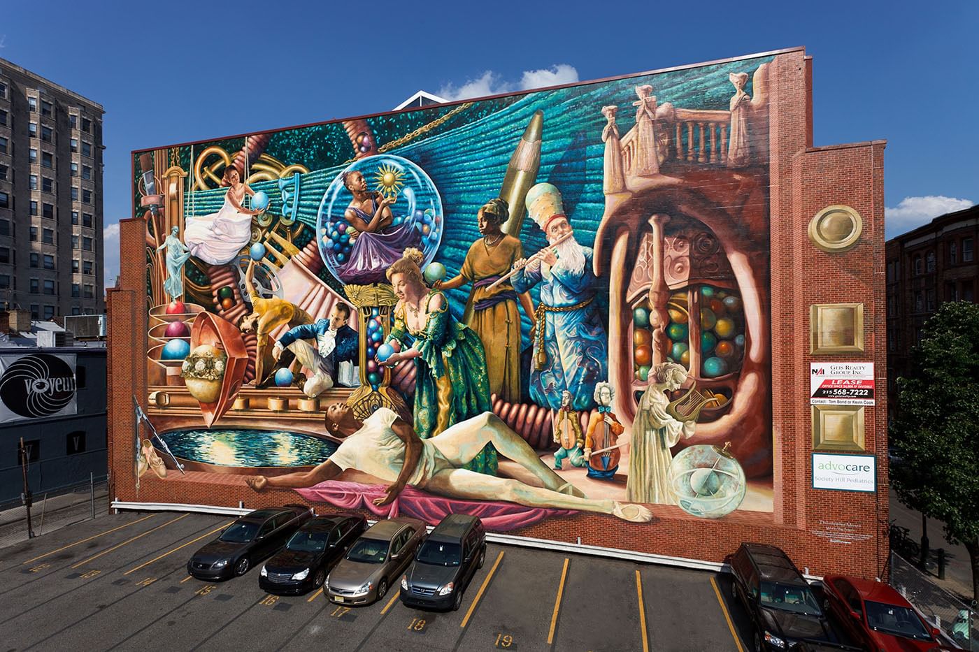 Large-scale view from aloft of the huge, vibrant mural, with diverse human figures making art and music.