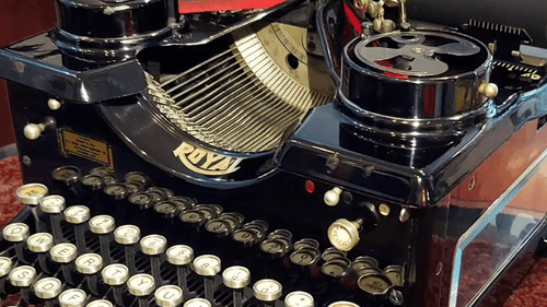 Close-up on a large, well-polished vintage typewriter a black body and round white keys.