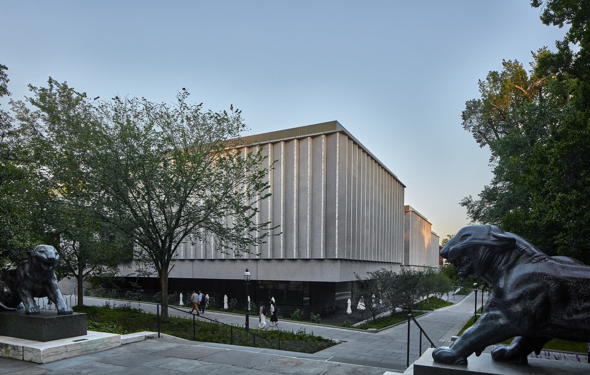 Exterior daytime view of the museum complex, surrounded by green grass, trees, and paths, and large lion sculptures.