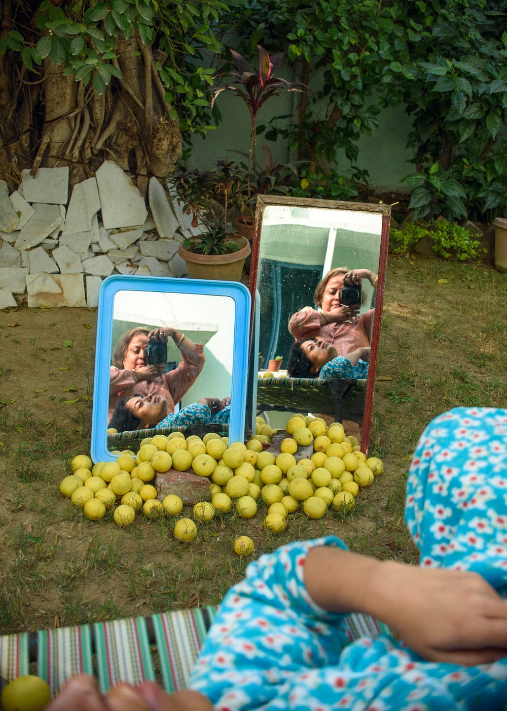 Outside, in front of a pile of lemons, two mirrors capture Mukherji and her mother making a dual portrait.