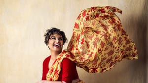 Shetty poses in a floral print silk saree, laughing. Part of the saree floats in the air like its blowing in the wind