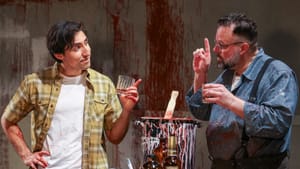 In front of a large canvas spattered with red, the men talk avidly to each other, each holding a whiskey glass.