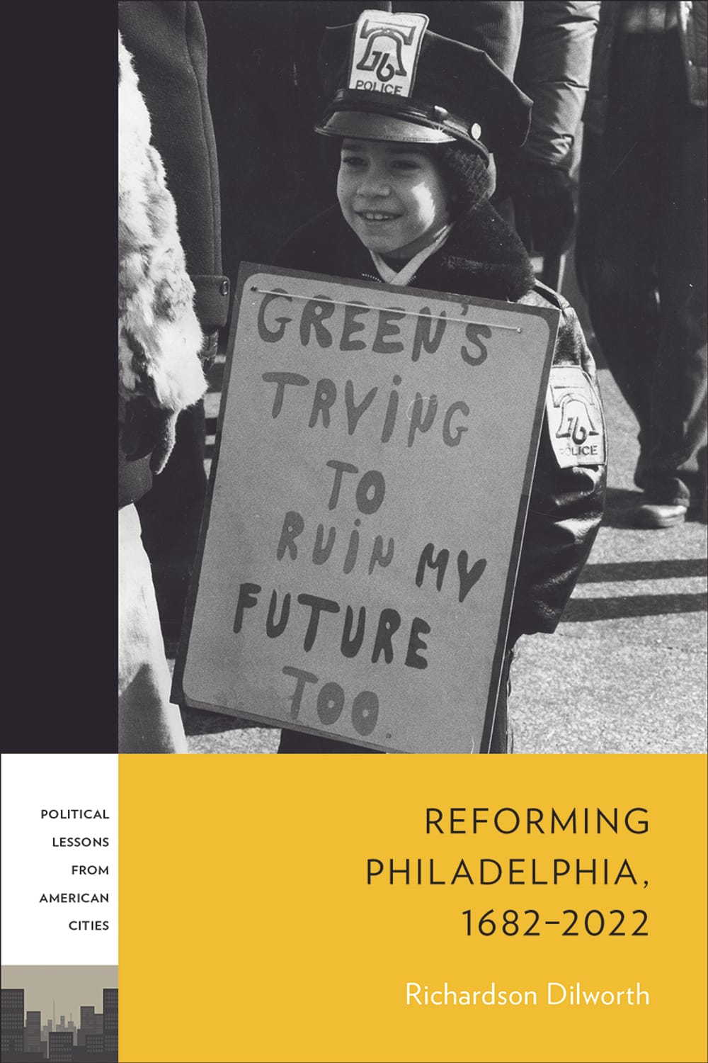 The cover: black & white photo of small boy in a police uniform holding a protest sign; title in yellow block at bottom right