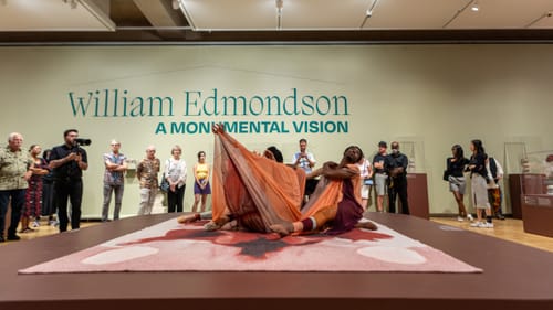 Dancers in Returning to Before, writhing and emerging from mesh fabric, perform in the crowded Edmondson gallery