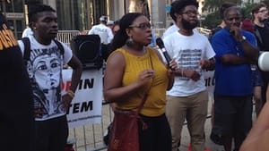 Meagan, a speaker for Philly for REAL Justice, addresses the crowd as the bronze Rizzo vies for their attention. (Photo by Alaina Johns.)