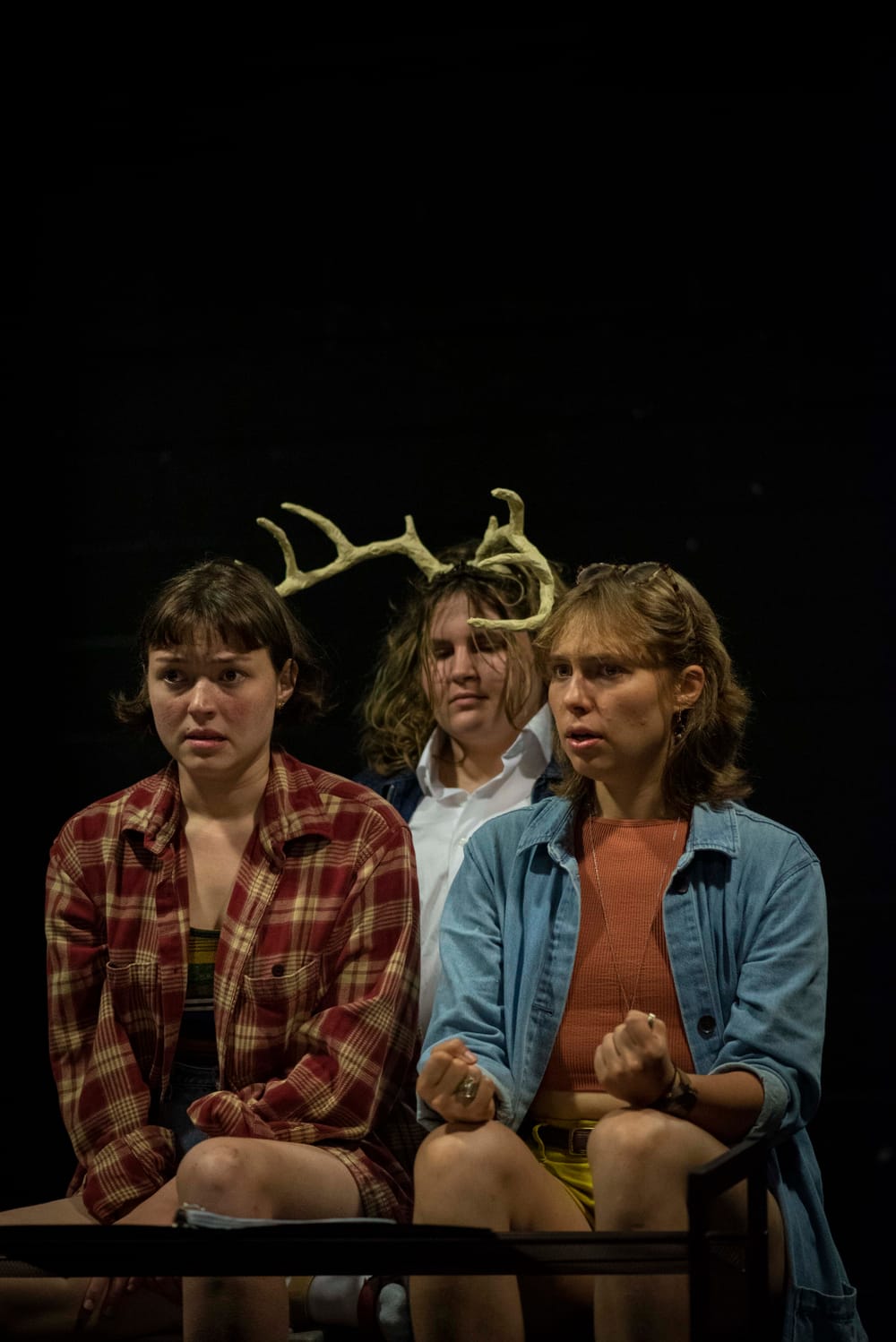 Against a black background, the actors sit together as if crowded in a car, with Presley in the back, wearing deer antlers.