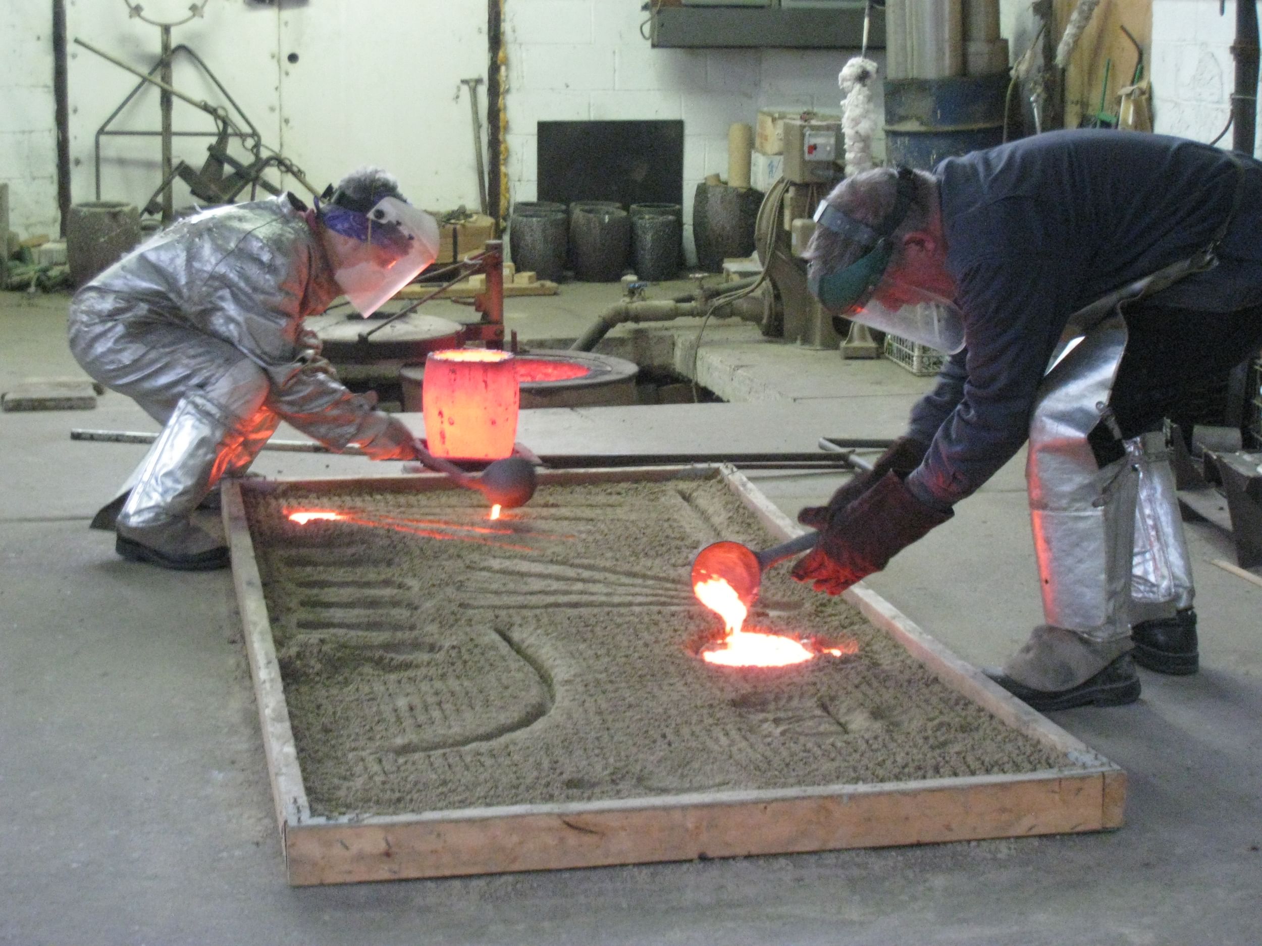 Fresh metal: Gina Michaels (left) and John Phillips work together on open-sand casting. (Photo courtesy of Gina Michaels.)