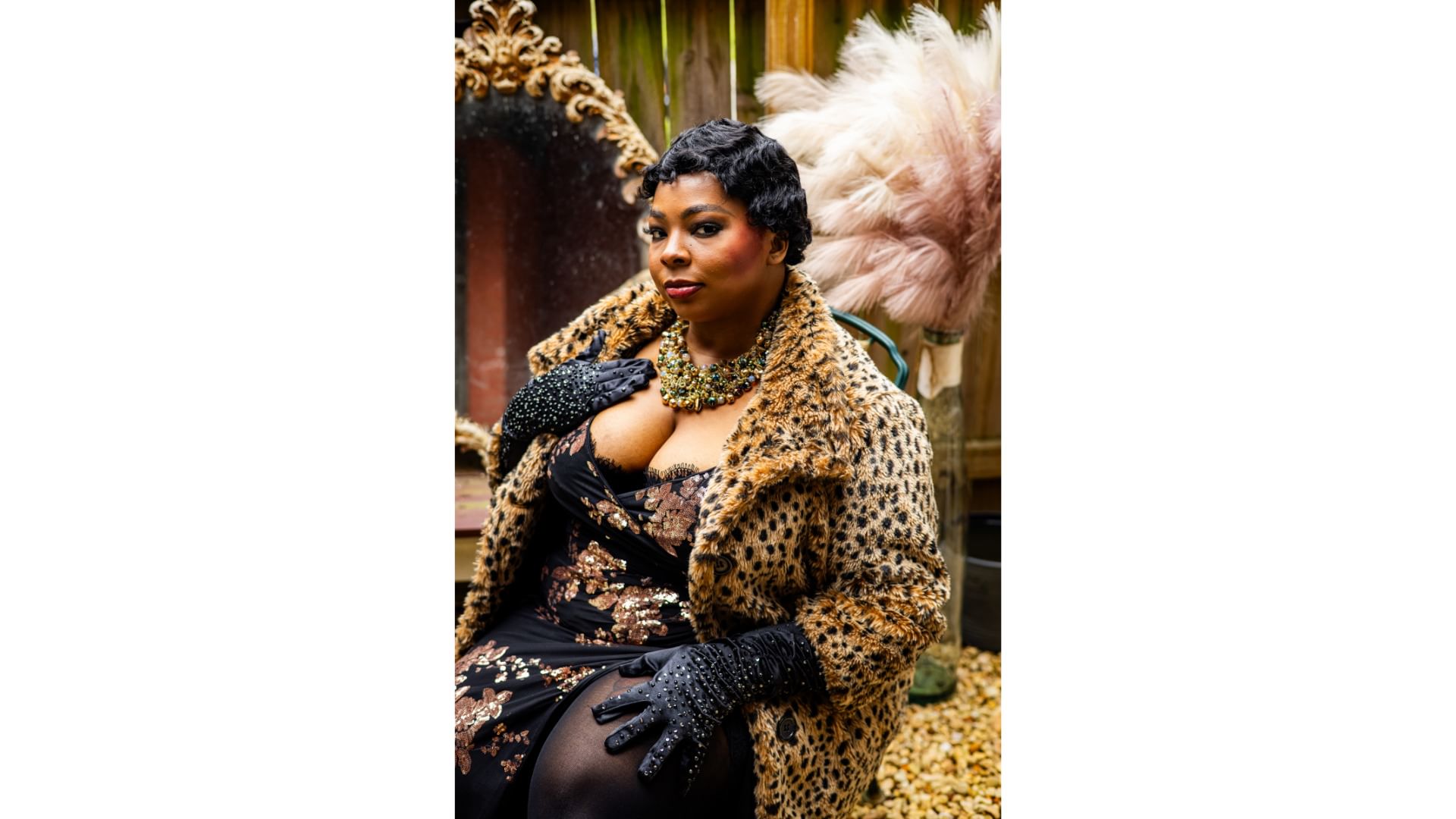 Cheri poses seductively in a low-cut evening dress, leopard-print coat, beaded gloves & necklace, and short permed hair.