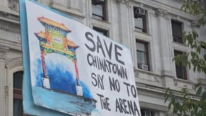 Handmade sign waving outside City Hall has painted illustration of Philly’s Chinatown arch and “say no the arena” on it