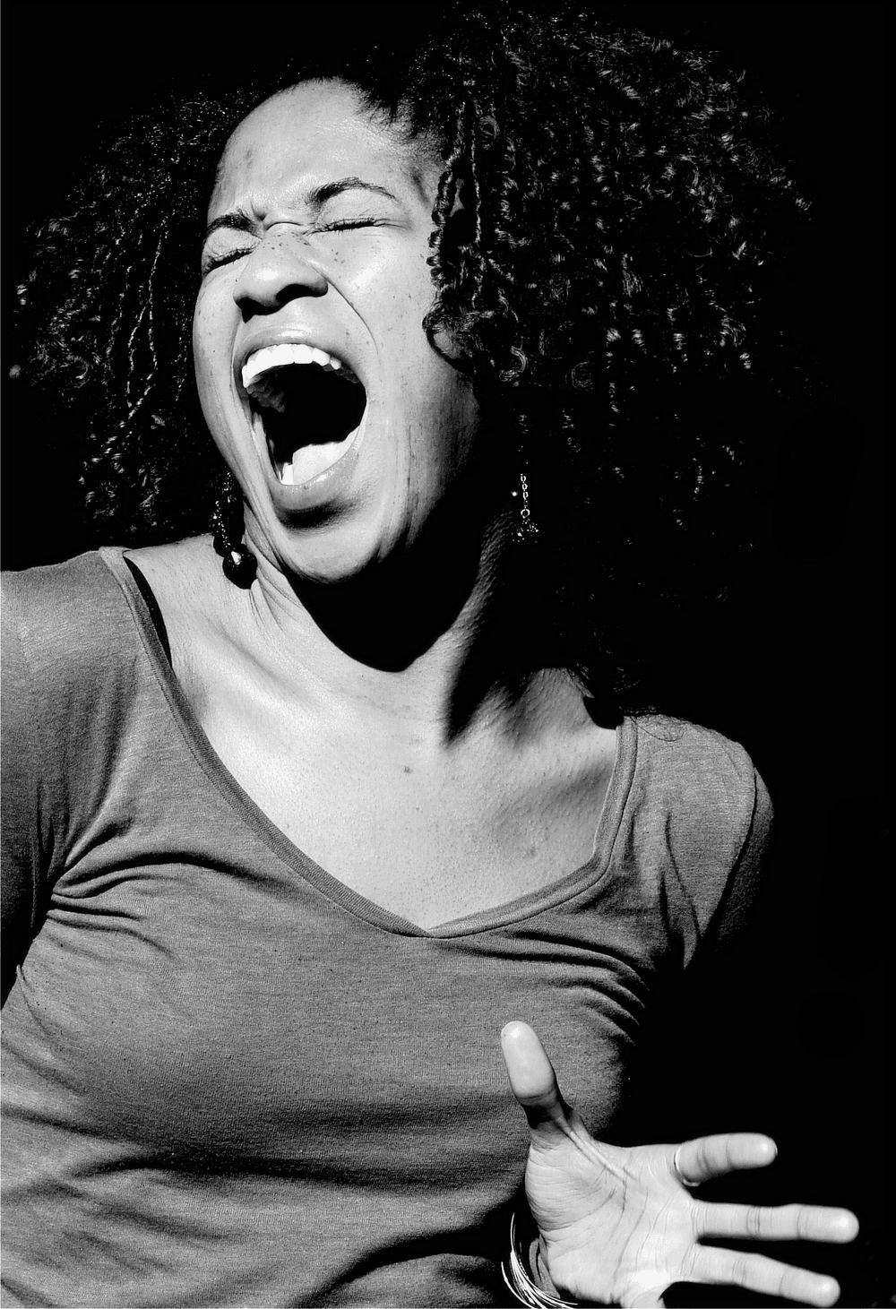 A portrait of Norris. She's singing, her mouth agape and hands open, her eyes closed. The photo is in black and white