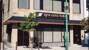 Photo of outside of Sigma Sound Studio, a sign above the awning, windows with closed shades, on the corner of a street