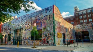 Outdoor daytime shot of old Painted Bride building with glass mosaic mural all along the entire sides of the building.