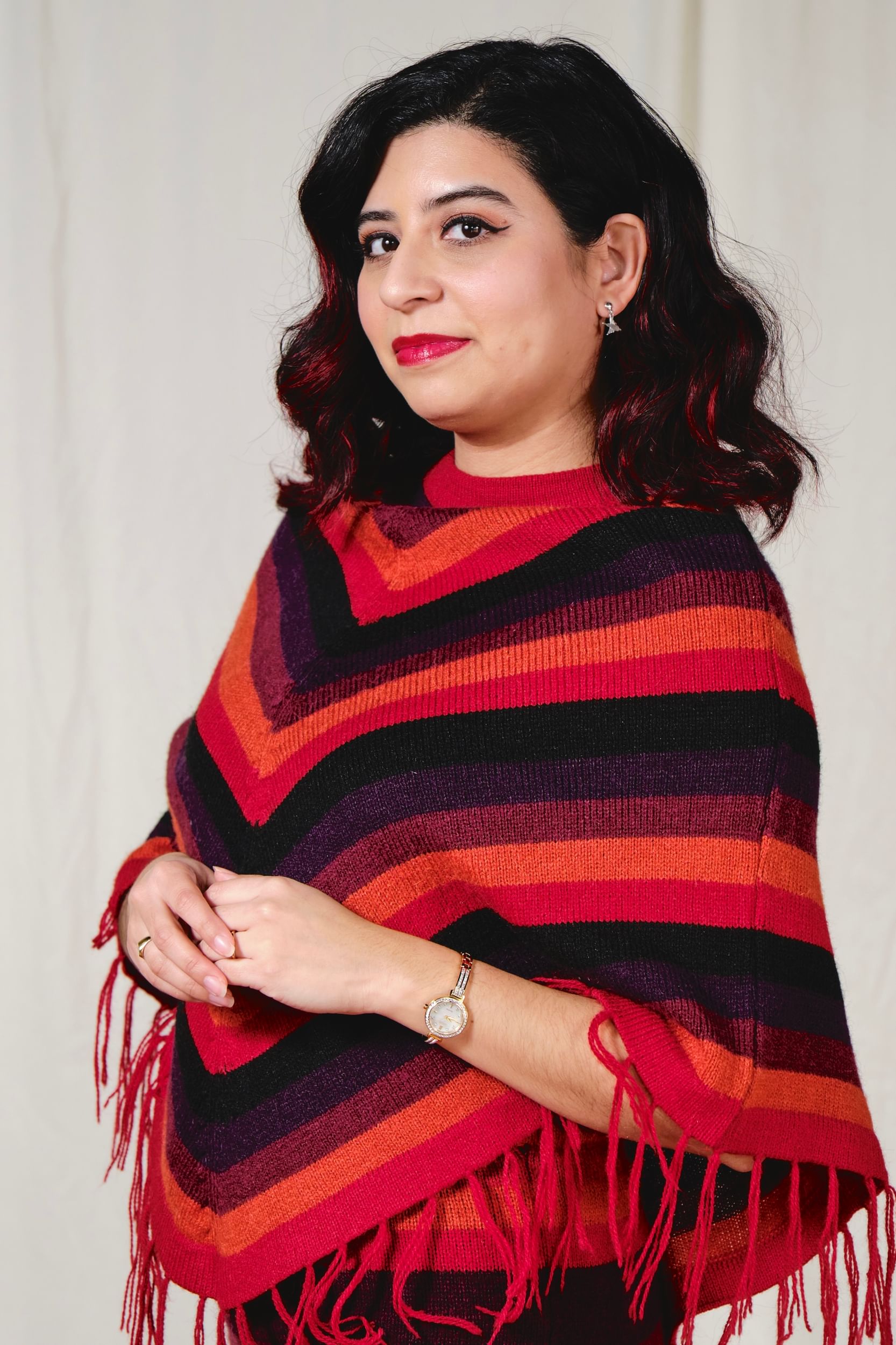 Portrait style photo of Sotomayor, a Peruvian woman, in a red, black, and orange shawl