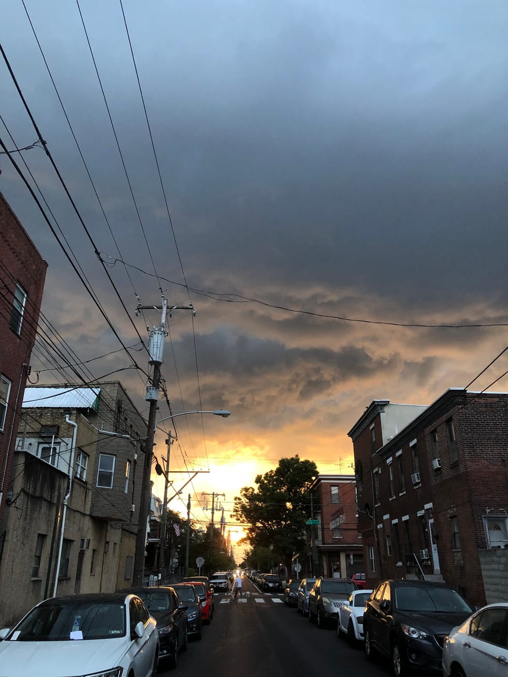 Sunset facing west on a South Philly street: pearly gray clouds give way to a golden sun where all the horizon lines converge