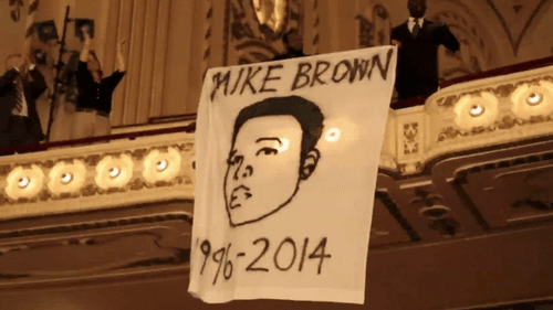 Protesters hung banners during a St. Louis Orchestra intermission and sang a "Requiem for Michael Brown." (Image via youtube.com.)