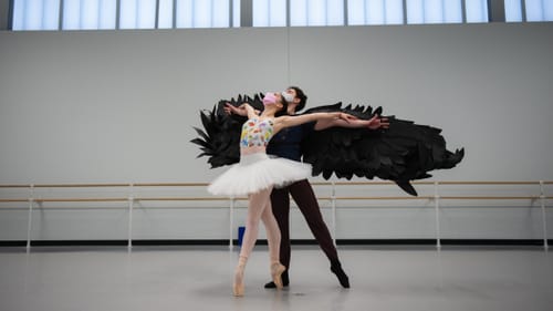 Two ballet dancers next to each other. In front is Torriente in a tutu, w/ Baca behind her in all black with long black wings