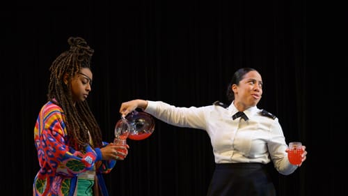 Bowers looks gravely into her cup as Canales, looking away, pours her a bright pink drink from a glass pitcher.
