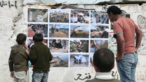 A photograph is never neutral: Residents of Bil'in examine an ActiveStills exhibit during a popular-struggle protest in the West Bank in July 2007. (Image courtesy of Slought.)