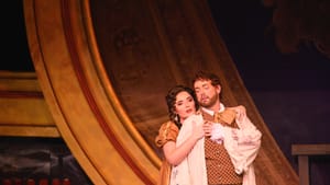 Closeup on the two actors, in lush period costumes, embracing in a wistful, romantic way.