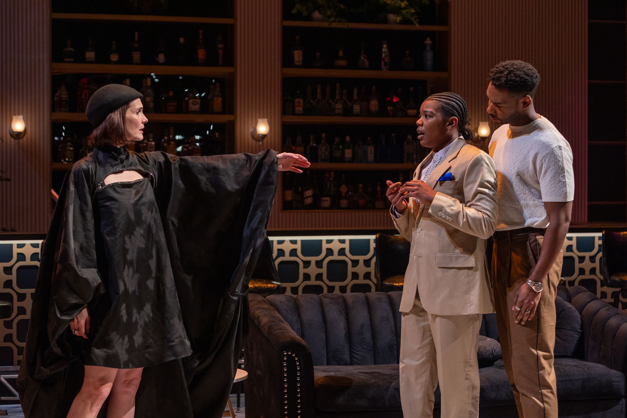 Zinkel, in black beret and voluminous black dress, reaches sadly toward Jones and Felix, who seem reluctant.