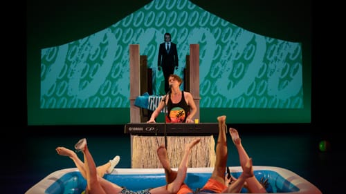 Conallen (Malvolio) paces on a pier above; Apple soulfully plays a keyboard; 4 sets of legs poke out intertwined from a pool