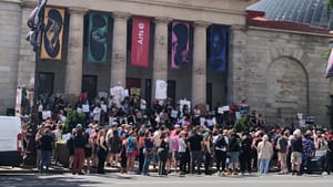 The pillared exterior of Hamilton Hall from across Broad Street, with 100s of people gathered in front of it, many with signs