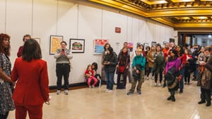 Gay and Landau, at far left, stand in front of a crowd in a bright, gilded corridor of City Hall turned into a gallery