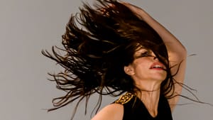 Close-up on Fudim, a white woman, dancing while her long brown hair flies, wildly suspended in the air.