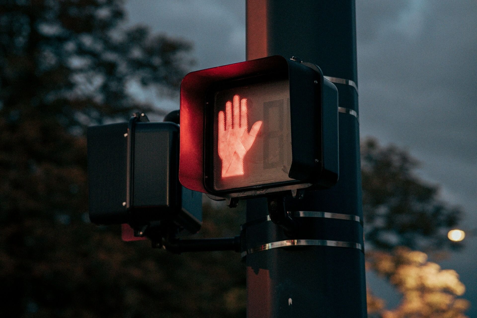 Close-up on a street crossing signal showing a red hand indicating don’t walk.