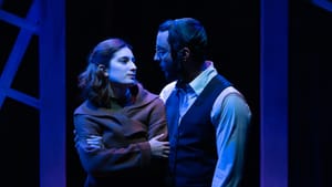 In a wash of blue light, Feldman & Howard play a Hasidic couple looking at each with tired but tender expressions.