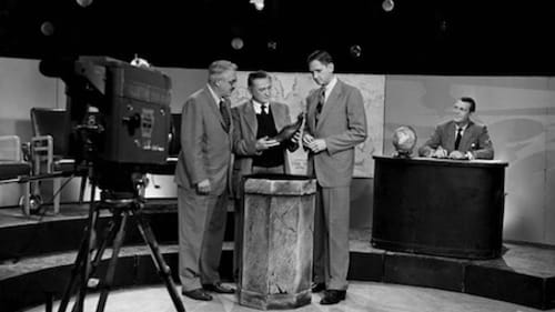 L to R: Penn anthropologist Carlton Coon, an unidentified panelist, and Schuyler Cammann examine an artifact, with Froelich Rainey at the desk. (Photo courtesy of the Penn Museum.)