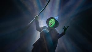 Valli sings triumphantly as Elphaba, with green skin, black robes, and a broomstick, in dramatic shafts of light.