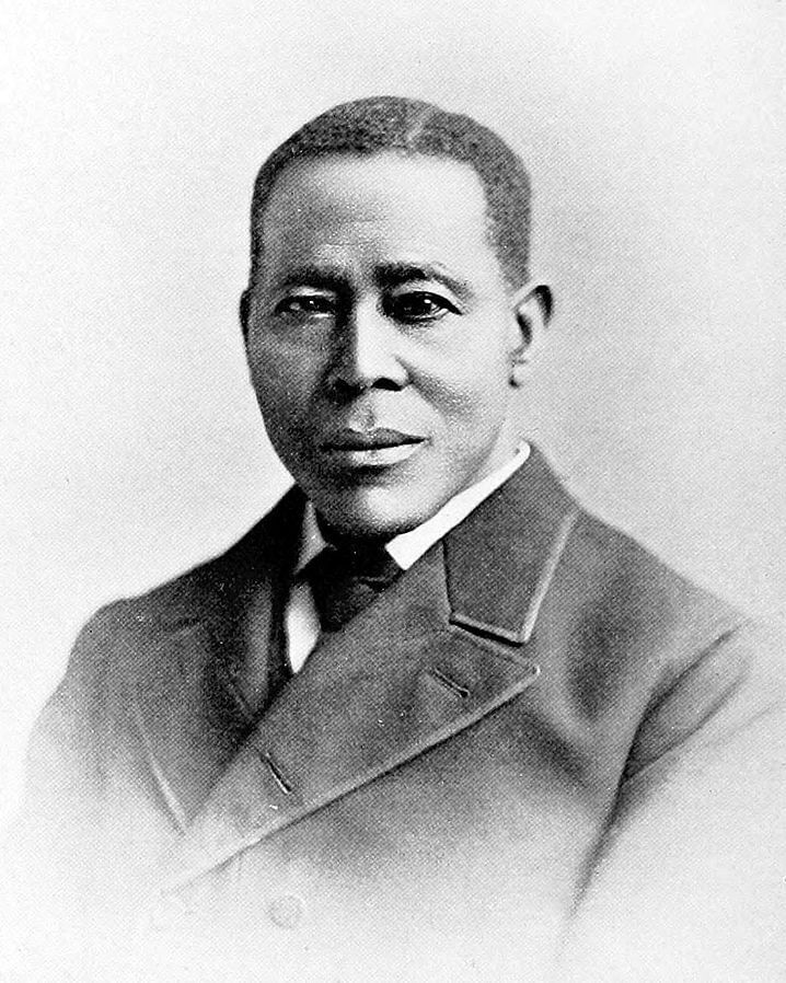 Historical black & white photo of Still, a Black man, looking calmly at the viewer, wearing a dark suit.